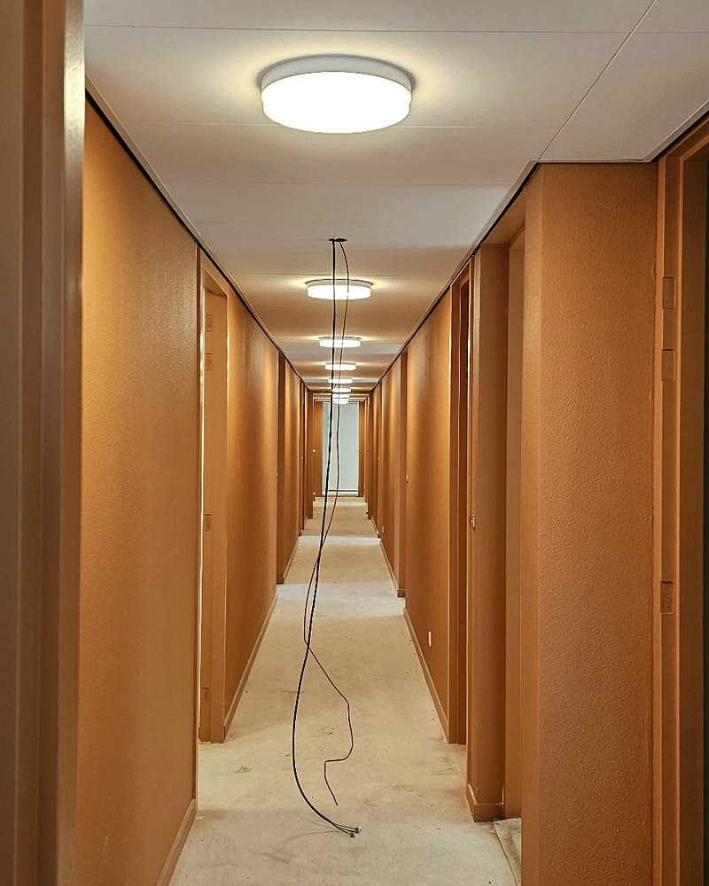 Lange gang met plafondlampen in een nieuwbouwproject